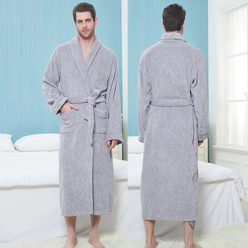 Homme portant le peignoir Pascal, un modèle épais et chaleureux en tissu éponge gris clair, présenté en vue de face et de dos dans une chambre lumineuse et cosy.