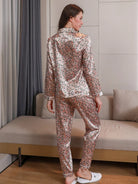 Femme vue de dos portant un pyjama long en satin rose imprimé de petits motifs floraux, composé d’un haut à manches longues et d’un pantalon fluide assorti. Ensemble tendance et agréable à porter, idéal pour les nuits douces ou les moments de détente à la maison.