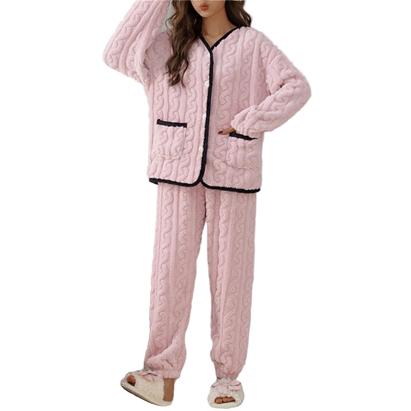 Femme portant le pyjama Percival, un ensemble d’hiver doux et chaud en tissu peluche rose, composé d’un haut boutonné à manches longues avec bordures noires et d’un pantalon assorti, idéal pour rester bien au chaud à la maison.