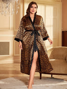 Kimono femme Philomène à imprimé léopard, coupe longue avec ceinture à nouer, manches trois-quarts et finitions contrastées, porté par un modèle dans un intérieur élégant.