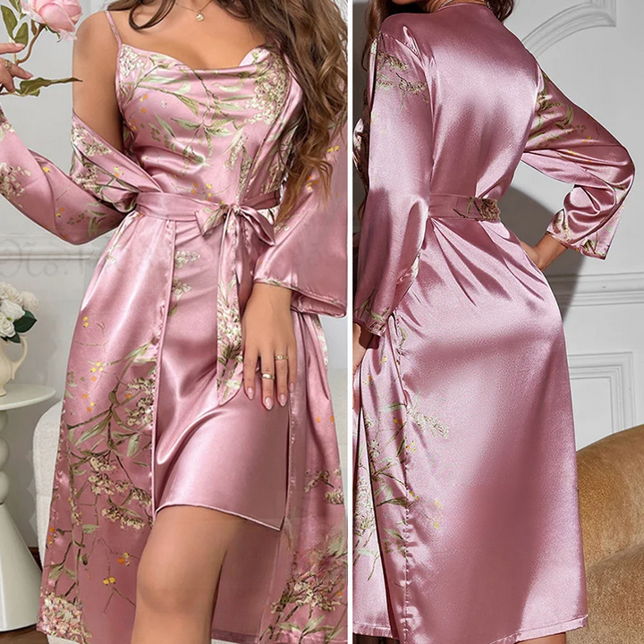 Nuisette en satin rose délicatement ornée de motifs floraux. La coupe élégante est accentuée par un décolleté séduisant et des manches longues légèrement évasées. Un lien à la taille permet d&