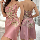 Nuisette en satin rose pâle, élégante et fluide, avec des bretelles fines et un décolleté en V subtil. Le tissu satiné est délicatement orné d'un motif floral élégant, dans des nuances de vert et d'or, qui apporte une touche de sophistication. La coupe ajustée épouse parfaitement les formes du corps, offrant une silhouette élégante et féminine, idéale pour une soirée ou un moment de détente chic.