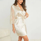 Kimono femme Quitterie en satin, coloris clair, avec manches en dentelle et ceinture à nouer, présenté porté pour mettre en valeur la coupe élégante et les finitions délicates.