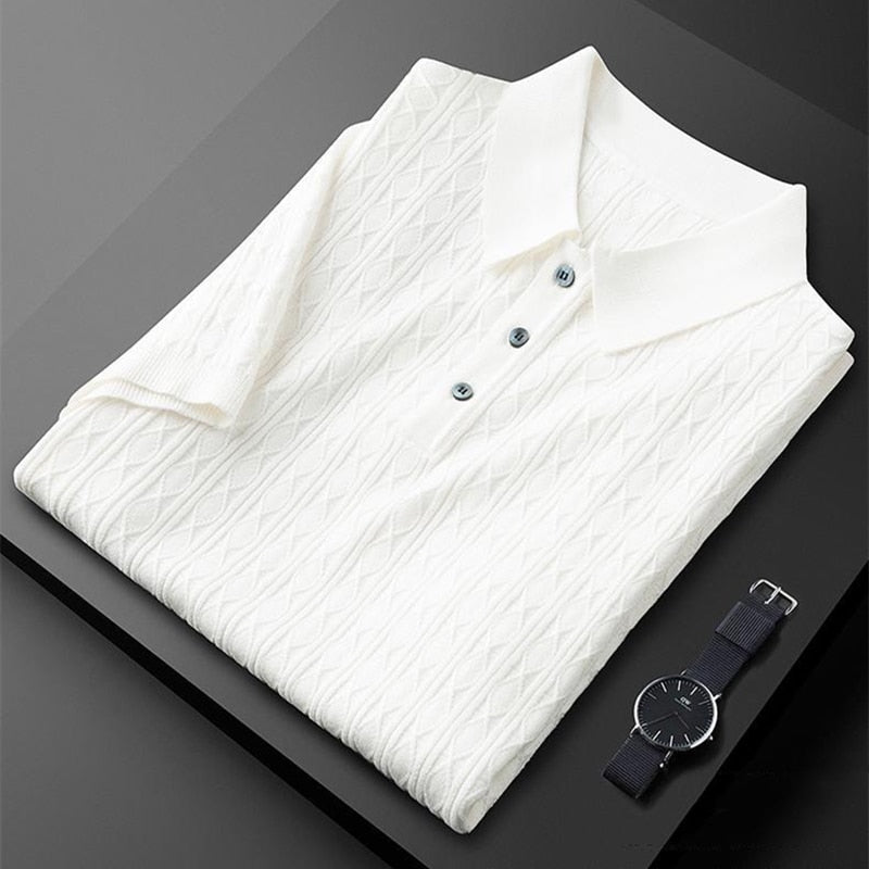 Polo blanc soigneusement plié avec des détails de boutons noirs, accompagné d&