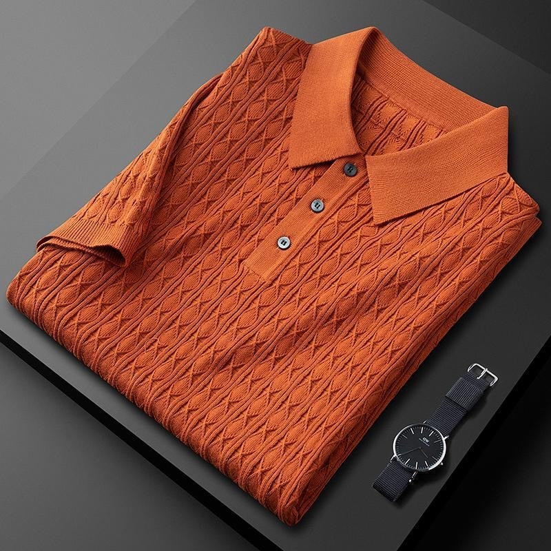 Polo orange plié avec des boutons noirs contrastés, accompagné d&