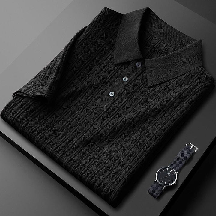 Polo noir plié avec des boutons noirs contrastés, accompagné d&