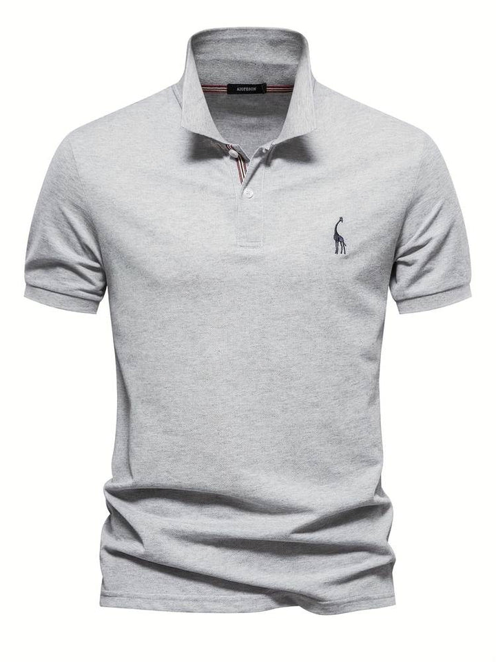 Ce polo slim pour homme, de couleur grise, présente un design moderne avec un col contrasté et un logo de girafe brodé sur la poitrine. Sa coupe ajustée assure un look élégant et raffiné, tout en offrant un confort optimal. Parfait pour un style décontracté mais sophistiqué, il est idéal pour toutes les occasions.