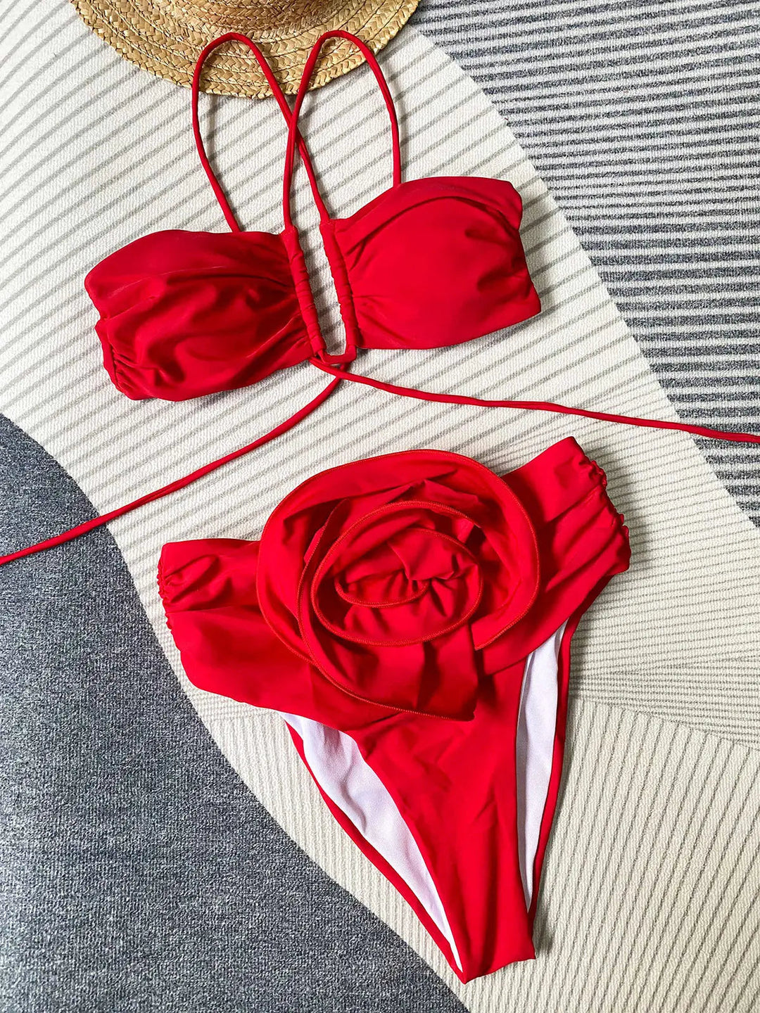 Ce bikini rouge raffiné avec un haut à lanières croisées et un bas décoré d’une grande fleur apporte une touche de féminité et de charme, parfait pour les journées estivales.