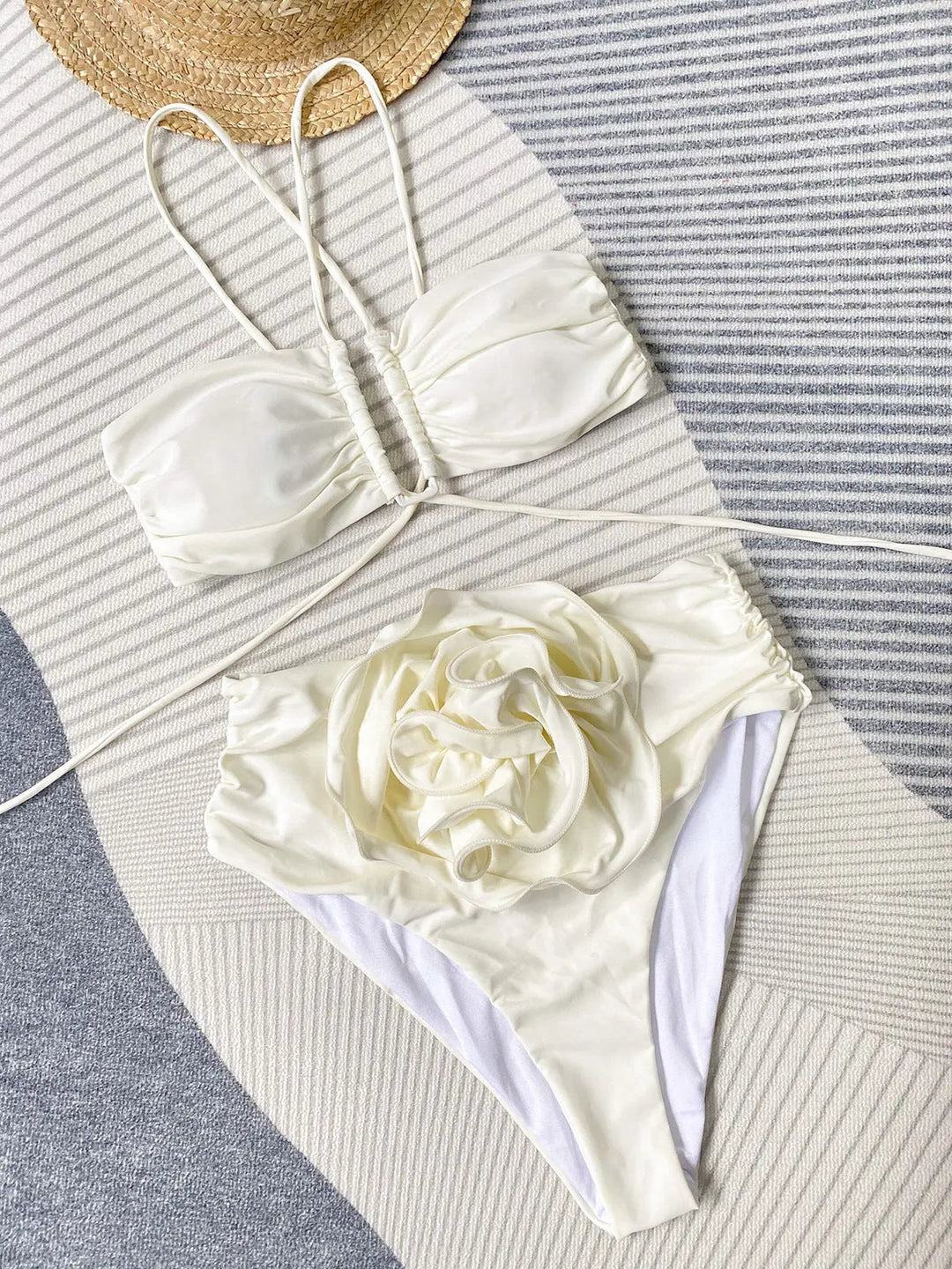 Ce bikini blanc sophistiqué avec son haut à bandes croisées et son bas décoré d&