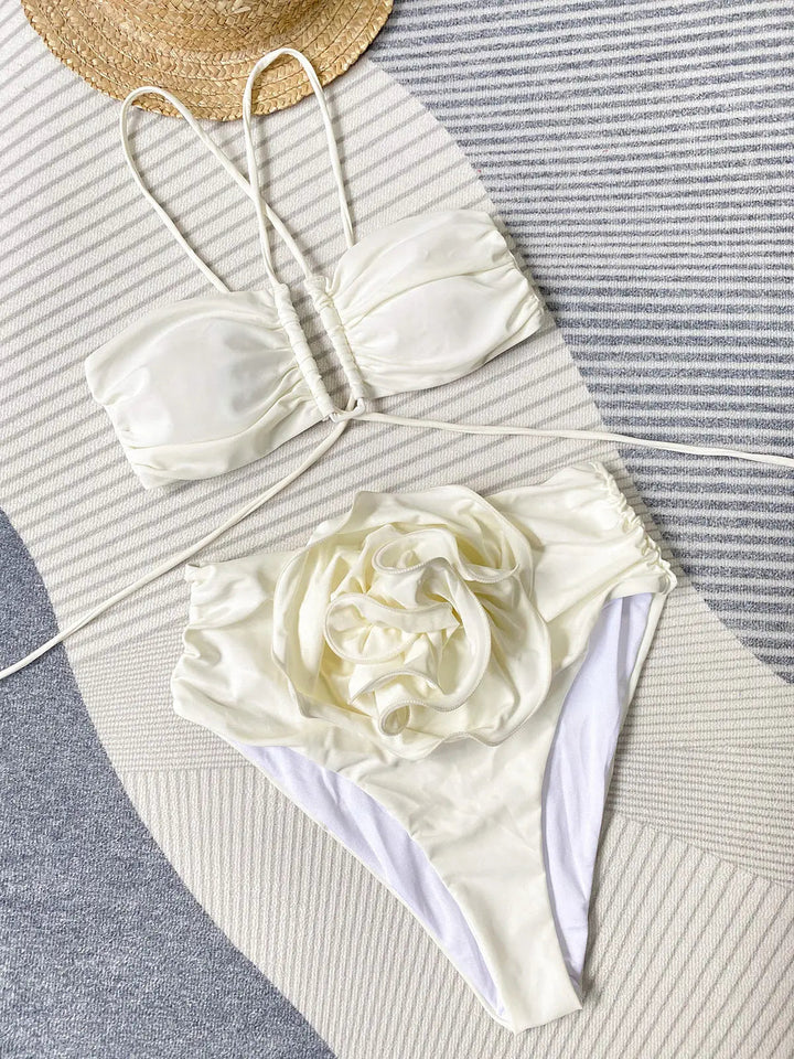Ce bikini blanc sophistiqué avec son haut à bandes croisées et son bas décoré d&