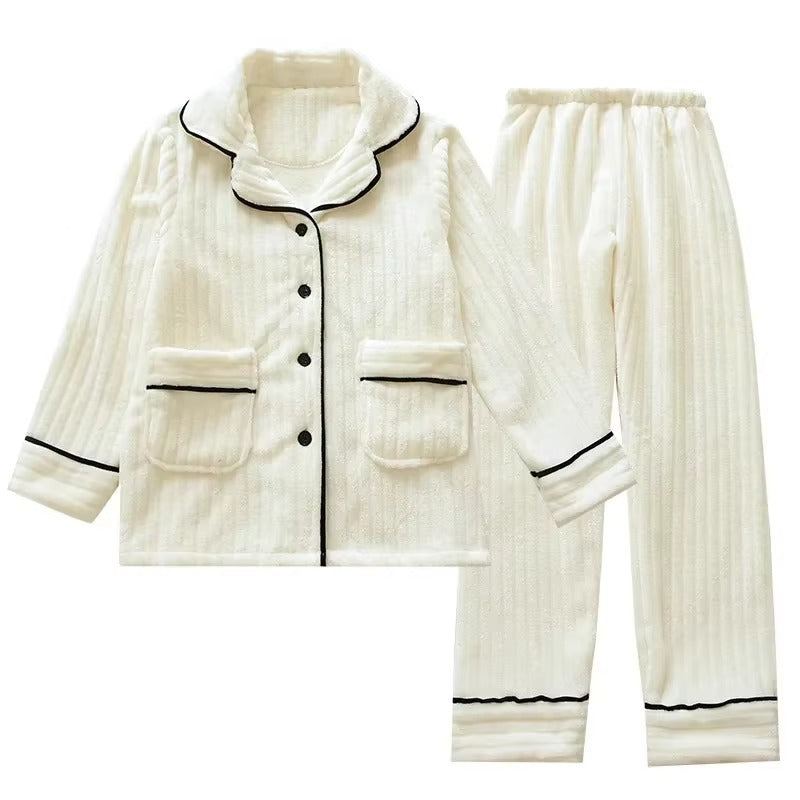 Pyjama femme deux pièces en tissu crème à texture côtelée, avec veste boutonnée à col châle, poches plaquées et finitions noires contrastantes. Ensemble chaud, élégant et très confortable, idéal pour l’hiver.