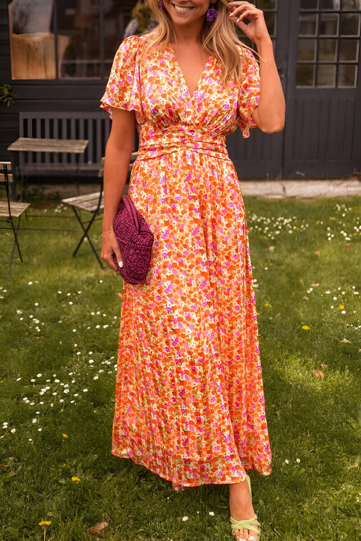 Robe maxi fluide à imprimé floral coloré, avec décolleté en V et taille cintrée pour une silhouette féminine. Légère et agréable à porter, elle est idéale pour les journées ensoleillées ou les occasions estivales élégantes.