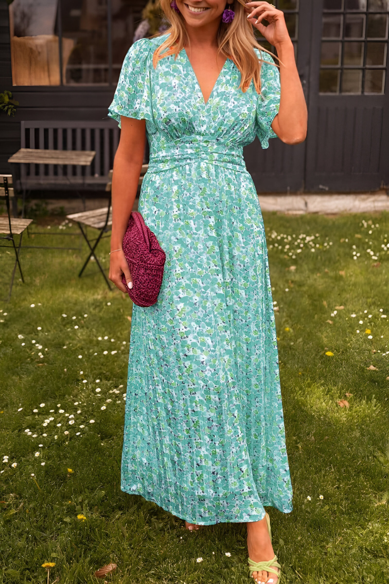Robe maxi fluide vert pastel à imprimé floral, avec décolleté en V et taille cintrée qui souligne la silhouette. Légère et confortable, elle est parfaite pour un look chic et féminin lors des journées ensoleillées ou des occasions estivales.