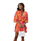 Robe mini fleurie pour femme aux couleurs vives, avec des motifs floraux roses et oranges. Légère et confortable, idéale pour l'été et les journées ensoleillées.