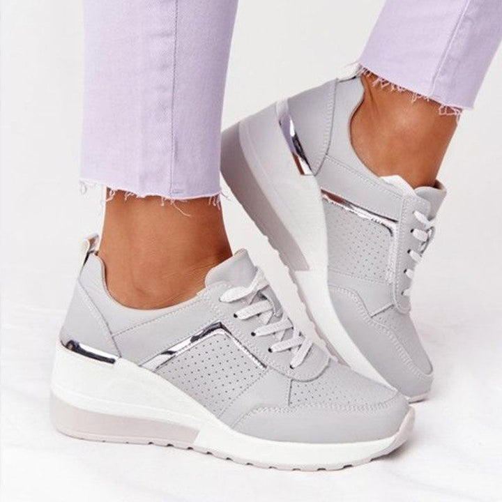 Baskets en cuir gris avec détails métalliques, conçues pour offrir un confort optimal tout en restant élégantes. Parfaites pour un look décontracté et moderne, idéales pour le quotidien.
