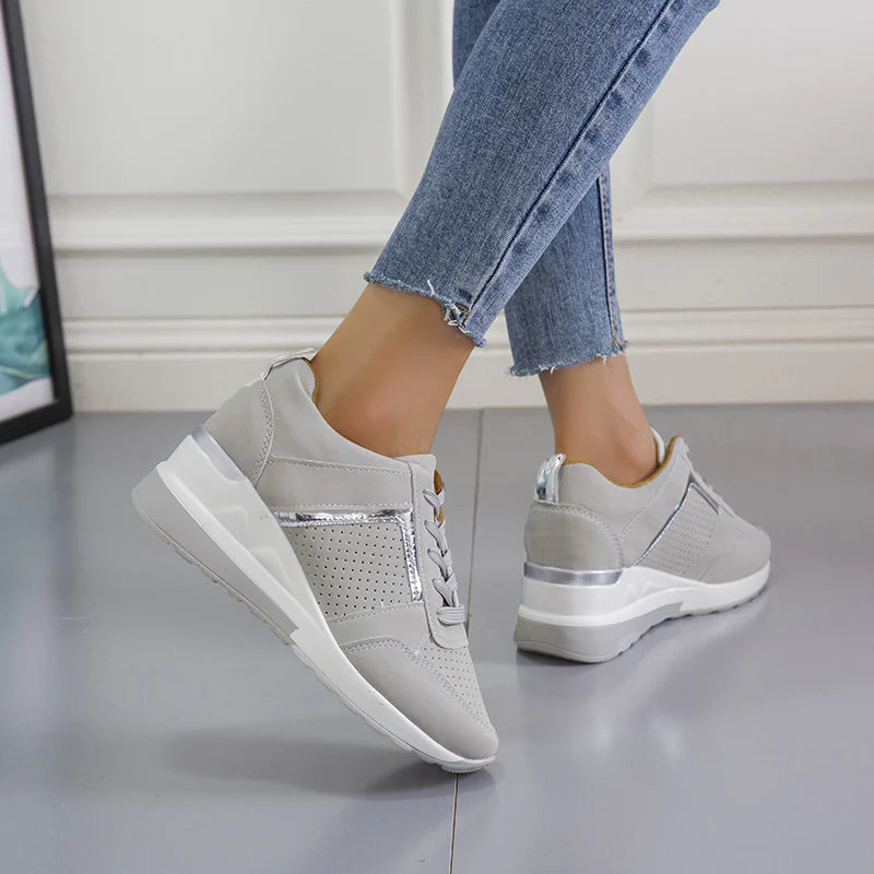 Baskets en cuir gris avec détails métalliques et semelle compensée, alliant confort et style moderne. Idéales pour une tenue décontractée tout en restant élégante au quotidien.