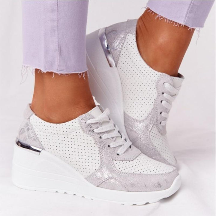 Baskets en cuir blanc et argent, avec détails perforés et semelle compensée, alliant confort et style. Idéales pour une utilisation quotidienne, ces baskets élégantes sont conçues pour vous offrir à la fois soutien et une touche de modernité.