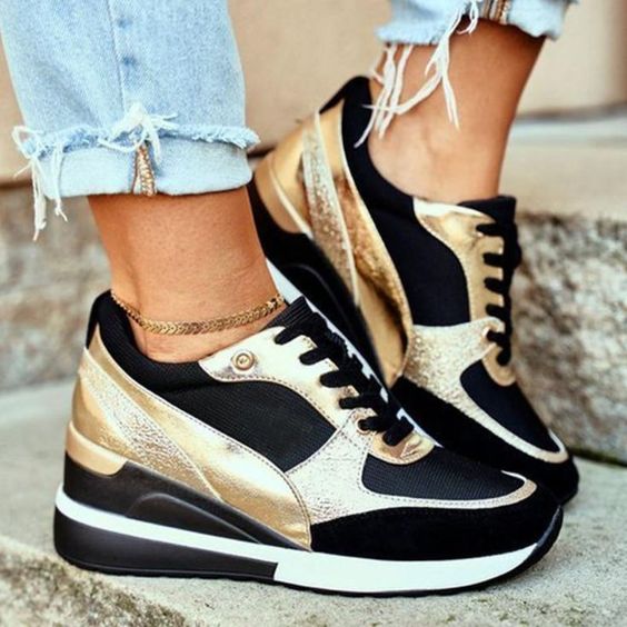 Baskets noires et dorées en cuir, avec détails métalliques et semelle compensée, parfaites pour ajouter une touche sportive et chic à votre look quotidien. Confort et élégance réunis pour un style moderne et pratique.