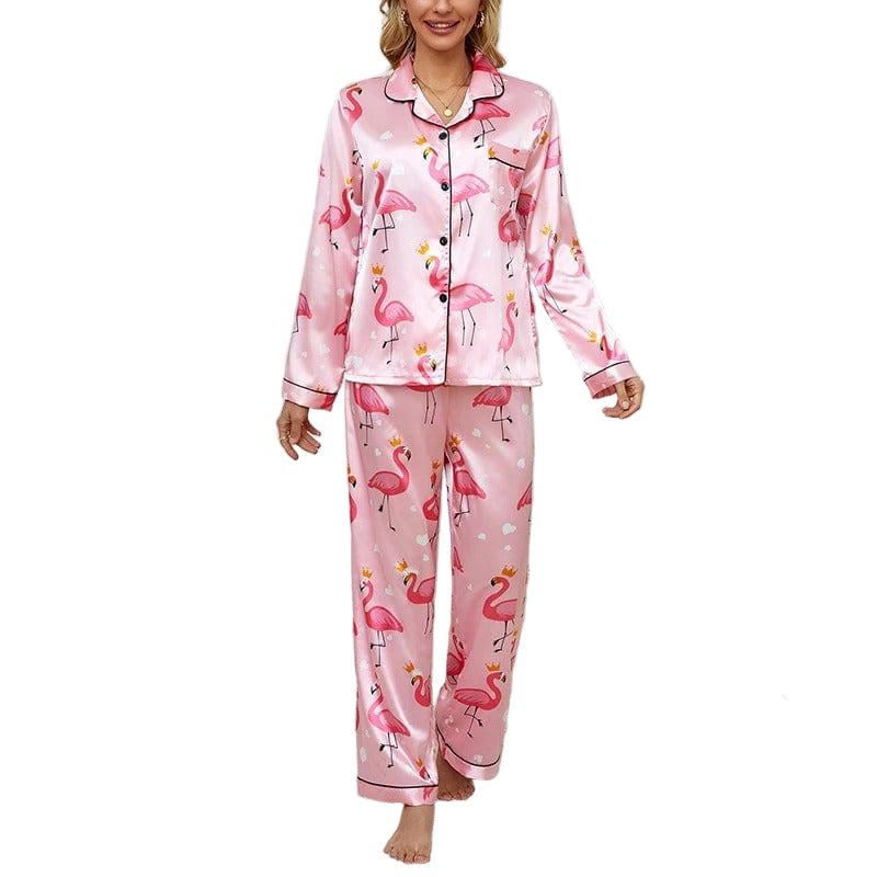 Femme portant un pyjama deux pièces en satin rose à imprimé flamants roses avec couronnes, composé d’un haut à manches longues boutonné et d’un pantalon assorti. Tenue tendance, douce et agréable pour des nuits confortables avec une touche fun.