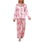 Femme portant un pyjama deux pièces en satin rose à imprimé flamants roses avec couronnes, composé d’un haut à manches longues boutonné et d’un pantalon assorti. Tenue tendance, douce et agréable pour des nuits confortables avec une touche fun.