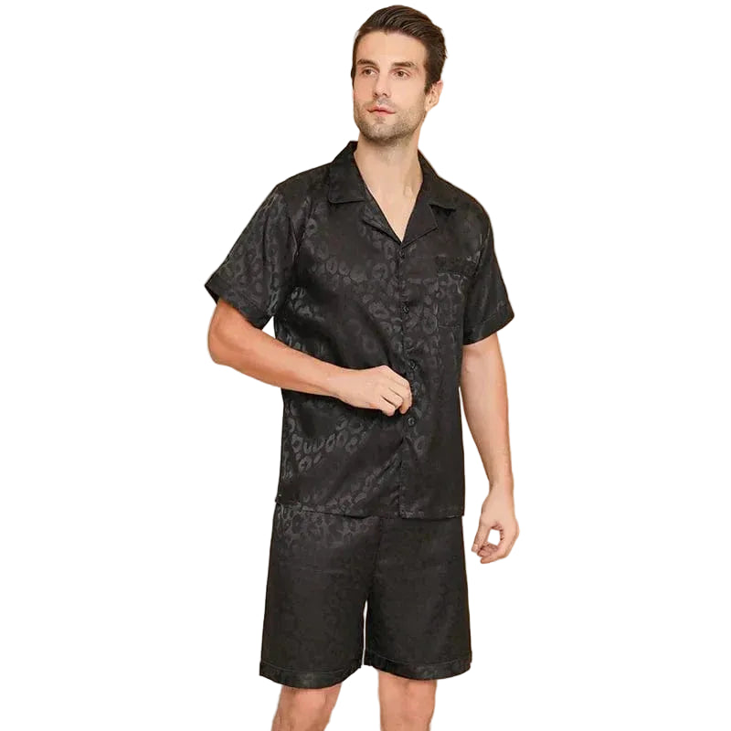 Vue de face d’un homme portant le shorty en satin pour homme Sylvain, ensemble noir satiné à motifs discrets avec chemise à manches courtes et short assorti, coupe fluide et tissu doux offrant un confort optimal, une allure élégante et une sensation agréable pour la nuit ou les moments de détente à la maison.