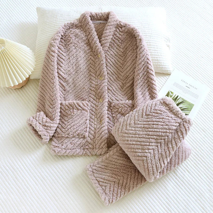 Pyjama femme en tissu pelucheux rose taupe avec motif chevron, composé d’une veste à boutons et poches plaquées, et d’un pantalon assorti. Ensemble épais, doux et chaleureux, idéal pour l’hiver et les journées cocooning à la maison.