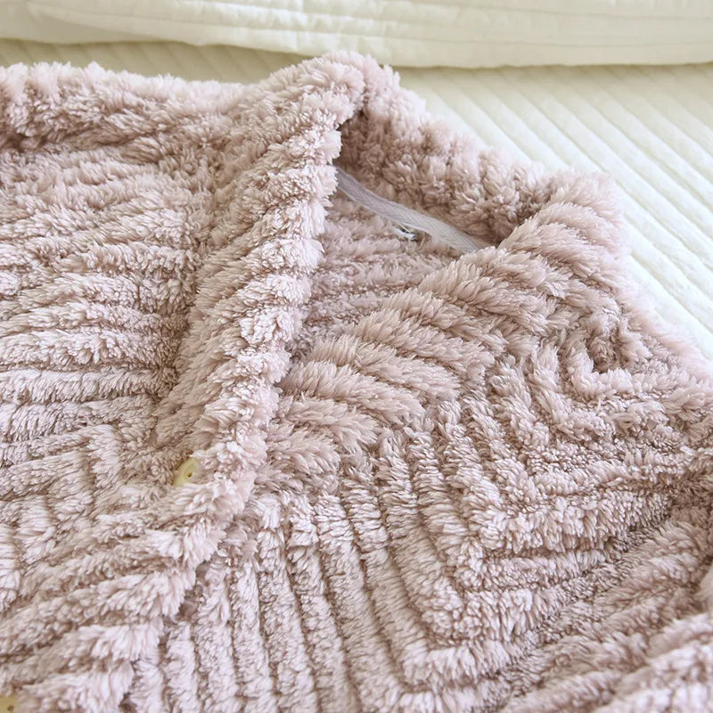 Gros plan sur le col et la texture en relief d’un pyjama femme rose taupe en tissu pelucheux à motif chevron. Matière douce, épaisse et moelleuse idéale pour l’hiver et le confort à la maison.