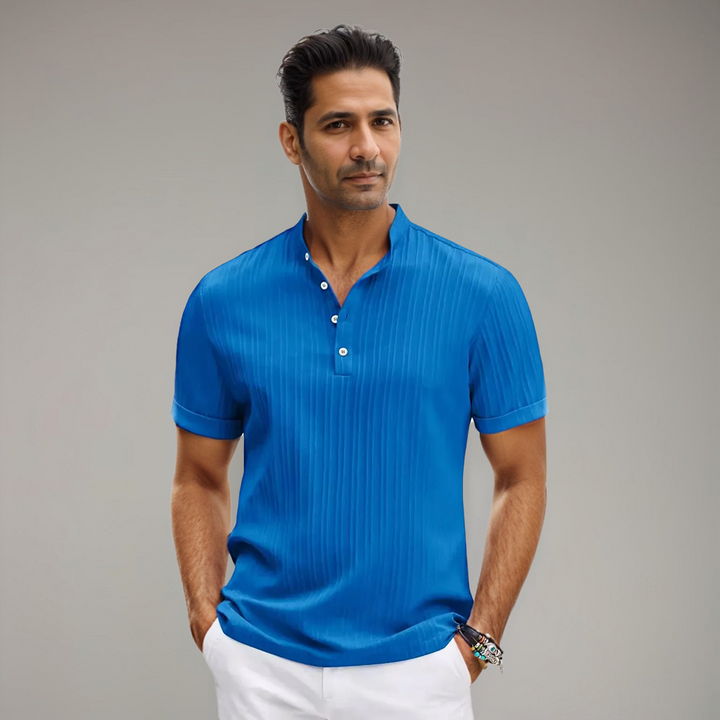 Polo bleu vif à rayures fines, porté par un homme avec un col montant et des boutons, offrant un look moderne et raffiné, parfait pour un style élégant et décontracté.