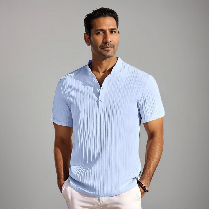 Polo bleu clair à rayures fines, porté par un homme avec un col montant et des boutons, offrant un look raffiné et moderne, parfait pour un style décontracté et élégant.