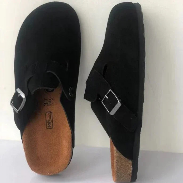Ces sandales Boston unisexes, en suède noir avec une boucle métallique ajustable et une semelle en liège, offrent un confort optimal et un design simple et élégant pour un look décontracté et stylé.