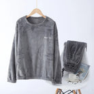 Pyjama femme Valérie en polaire gris clair, composé d’un haut à manches longues suspendu sur cintre et d’un pantalon assorti soigneusement posé sur une chaise blanche. Ensemble hivernal chaud, moelleux et confortable, parfait pour les moments de détente à la maison.