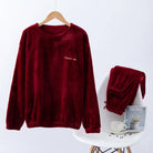 Pyjama femme Valérie en polaire rouge bordeaux, avec un haut à manches longues suspendu sur cintre et un pantalon assorti soigneusement posé sur une chaise blanche. Ensemble chaud et douillet, parfait pour affronter l’hiver avec confort et élégance.