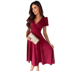 Élégante et fluide. Cette robe bordeaux à la coupe évasée et au décolleté en V, avec des manches bouffantes, est parfaite pour des occasions élégantes. Accessoirisée avec un sac à main doré, elle apporte une touche chic et féminine.