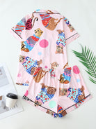 Pyjama femme deux pièces vu de dos, composé d’un haut à manches courtes et d’un short, en satin rose imprimé de félins colorés et de motifs graphiques. Style original et décontracté, parfait pour les nuits d’été ou les matinées relax à la maison.
