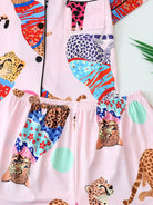 Vue rapprochée du pyjama femme Verity mettant en valeur les motifs léopard multicolores du haut et du short en satin rose. Tissu fluide, imprimé original et taille élastique pour un style fun et un confort optimal à la maison.