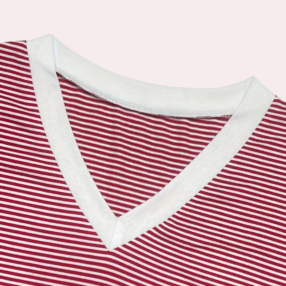 Gros plan sur le haut du pyjama Winifred, présentant un col en V bordé de blanc et un tissu à fines rayures rouges et blanches, offrant un style doux, élégant et confortable pour la maison.