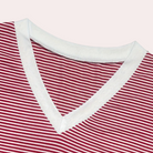 Gros plan sur le haut du pyjama Winifred, présentant un col en V bordé de blanc et un tissu à fines rayures rouges et blanches, offrant un style doux, élégant et confortable pour la maison.