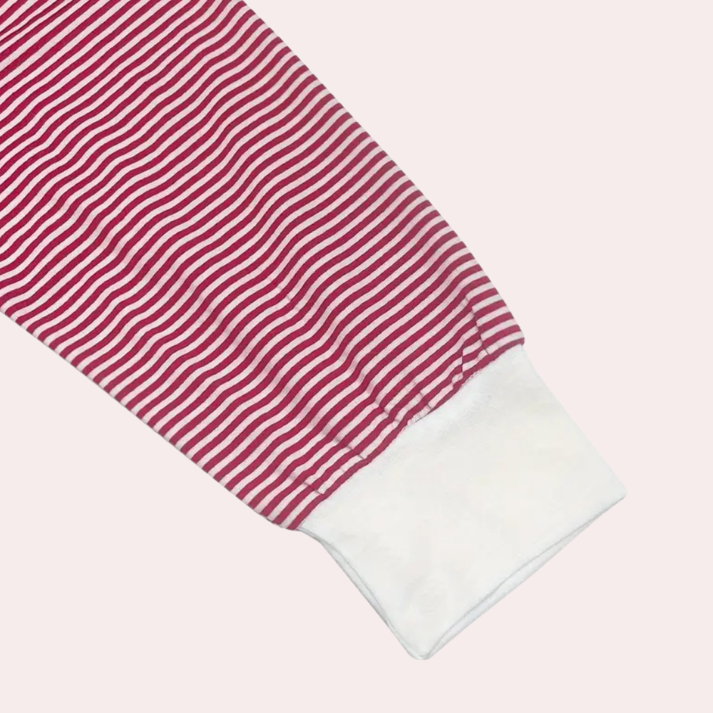 Gros plan sur la manche du haut du pyjama Winifred, en tissu à fines rayures rouges et blanches, avec un poignet blanc contrastant, soulignant un style doux, élégant et confortable.