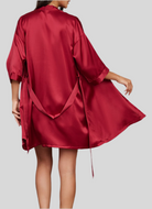 Robe de chambre en soie rouge, fluide et élégante, avec des manches courtes et des liens à la taille pour ajuster le vêtement. Ce peignoir satiné est à la fois chic et confortable, idéal pour se détendre à la maison.