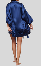 Peignoir en soie bleu, fluide et élégant, avec des manches trois-quarts et des liens à la taille pour un ajustement parfait. Ce modèle satiné offre à la fois confort et raffinement pour une touche chic à la maison.