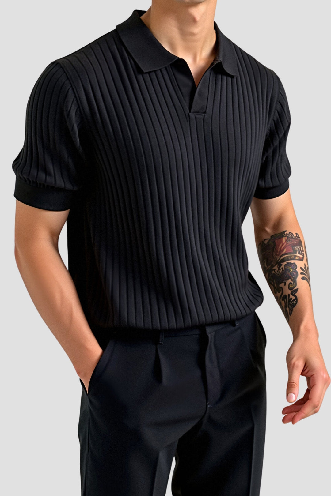 Polo côtelé noir porté par un homme avec un pantalon noir, mettant en valeur la coupe soignée et le design moderne, parfait pour un look raffiné et décontracté.