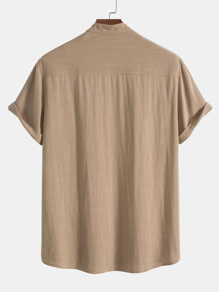 parfait pour l’été. Vue arrière du polo beige à col montant avec boutons, offrant un design simple et élégant, parfait pour les journées estivales.