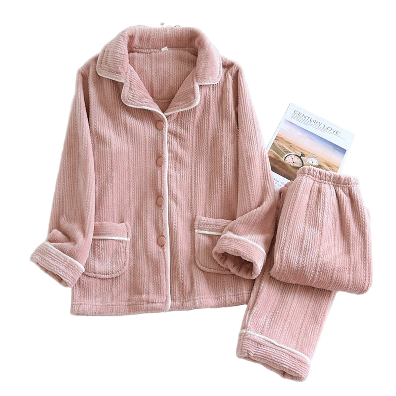 Pyjama pour femme en tissu rose poudré, composé d’une veste boutonnée à col et poches, et d’un pantalon assorti. Matière douce, chaude et moelleuse, idéale pour l’hiver et les soirées cocooning.