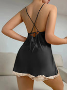 Vue de dos d’une femme portant la nuisette satinée noire de l’ensemble Zoraida, avec dos nu à bretelles croisées et finition en dentelle beige à l’ourlet. Lingerie élégante et fluide, idéale pour une allure séduisante et un confort raffiné.
