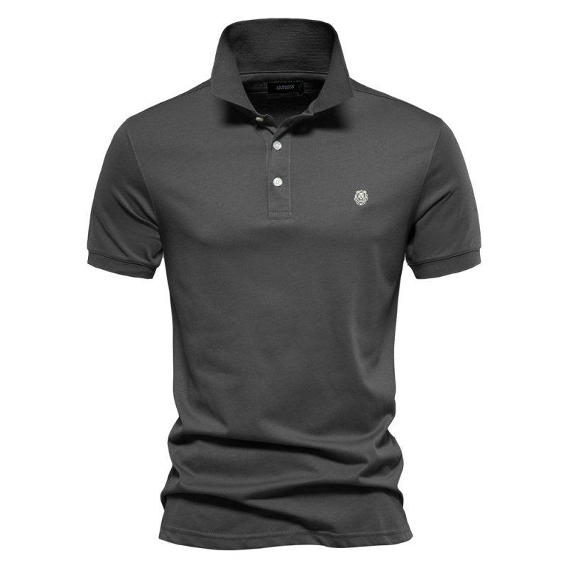 Ce polo gris foncé pour homme, à la coupe ajustée, est un choix élégant et moderne. Son design simple, avec un logo discret sur la poitrine, en fait un vêtement polyvalent, idéal pour un look à la fois raffiné et confortable pendant les journées estivales.