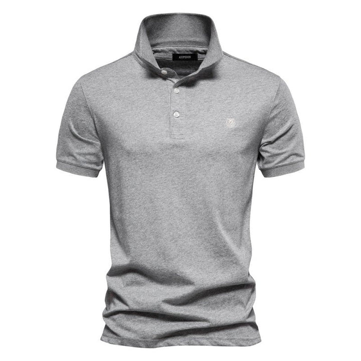 Ce polo gris pour homme à la coupe ajustée combine confort et style. Son design épuré, avec un logo discret sur la poitrine, en fait un choix parfait pour un look raffiné et décontracté lors des journées estivales.