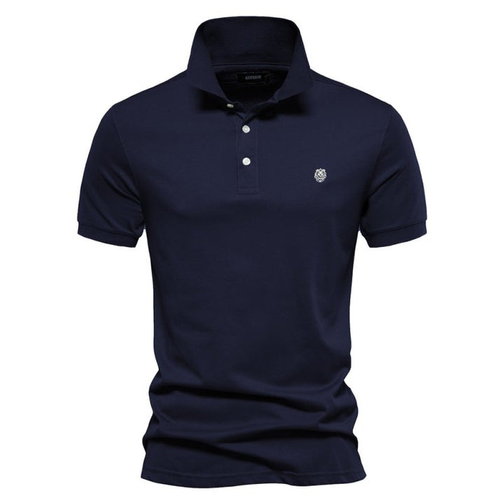 Ce polo bleu marine pour homme, à la coupe ajustée, allie élégance et confort. Avec son design simple et son logo discret sur la poitrine, il est idéal pour créer un look chic et décontracté pendant les journées estivales.