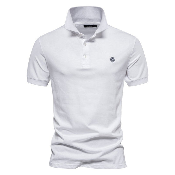Ce polo blanc pour homme à la coupe ajustée offre une silhouette moderne et élégante. Son design simple, avec un logo discret sur la poitrine, en fait le choix idéal pour un look raffiné et confortable, parfait pour les journées estivales.