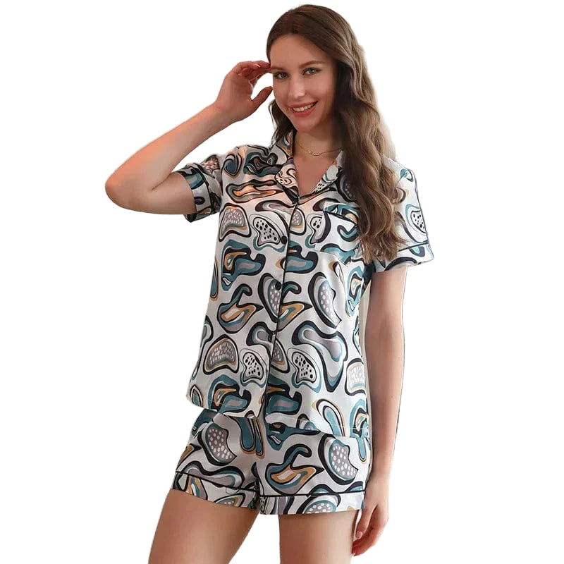 Femme portant le pyjama court femme, un ensemble estival léger et élégant composé d’une chemise à manches courtes et d’un short assorti, avec un motif abstrait aux tons doux. Parfait pour l’été et pour un confort chic à la maison.