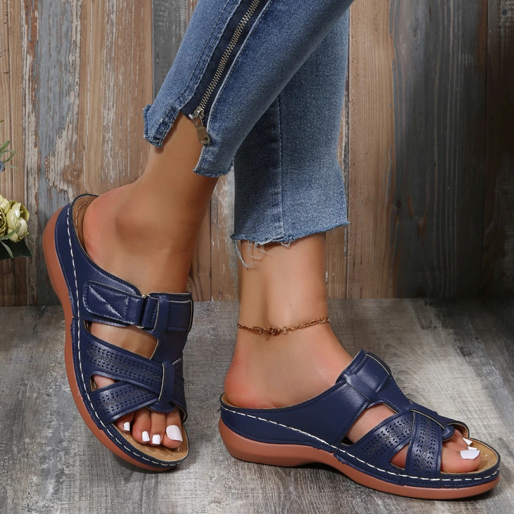 Sandales en cuir bleu marine avec des détails perforés pour une meilleure ventilation, dotées de boucles réglables pour un ajustement parfait, idéales pour les journées ensoleillées.